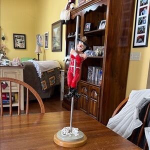 Clown firefighter slide down a pole with a Dalmation waiting for him